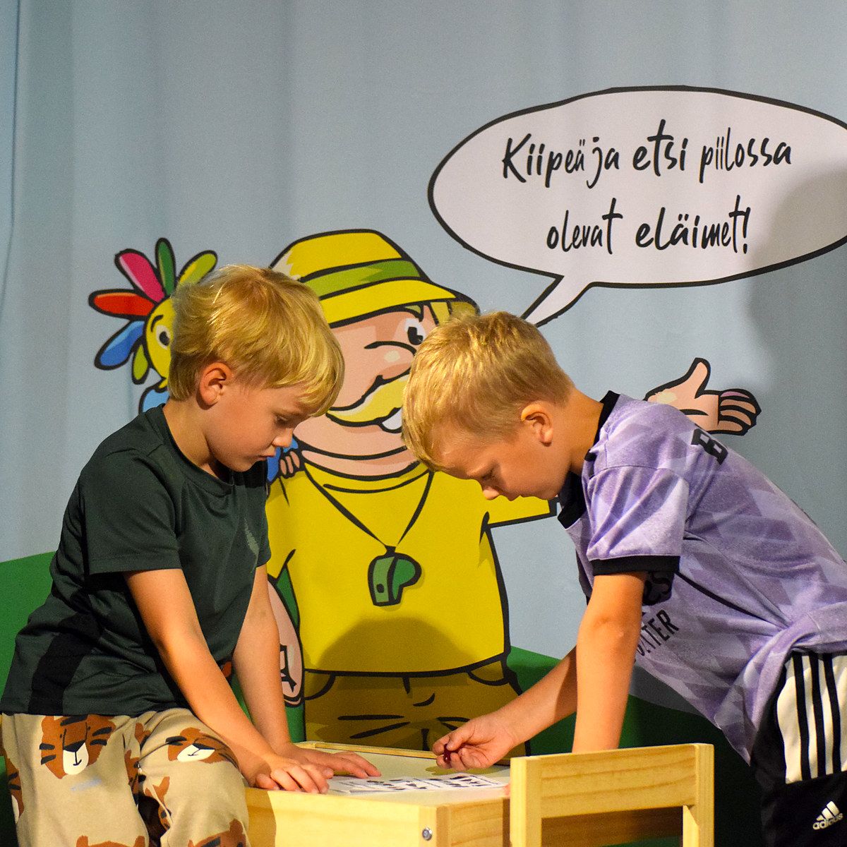 Lapsia touhuamassa kiipeilyseinien ympärillä.